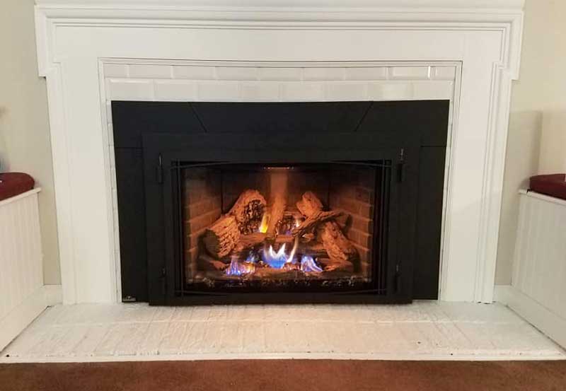 Gas fireplace inserts with white wood and subway tile surround as well as subway tile hearth