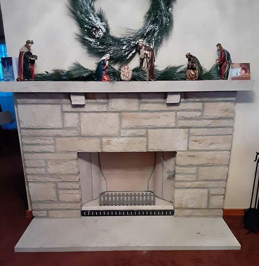 Ahren-Fire Firebox after installation granite hearth with rock surround and granite mantel decorated for Christmas.