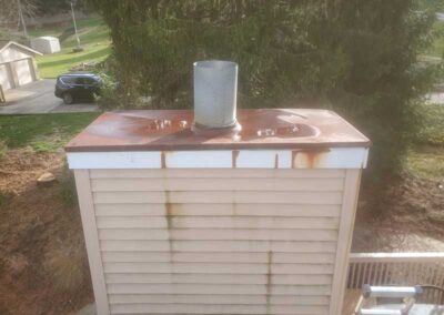 Chase Cover before replacement cover is all rusted with tree car and garage in basement in background and ladder in the foreground