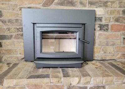 Wood Insert with black facing and glass door. Rock surround.