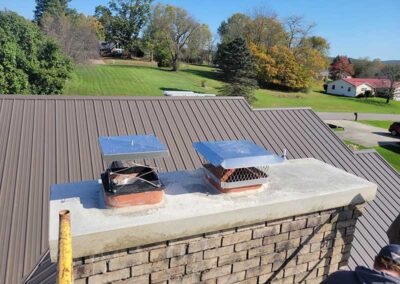 Chimney Crown after replacement - only two caps with trees and homes in the background.