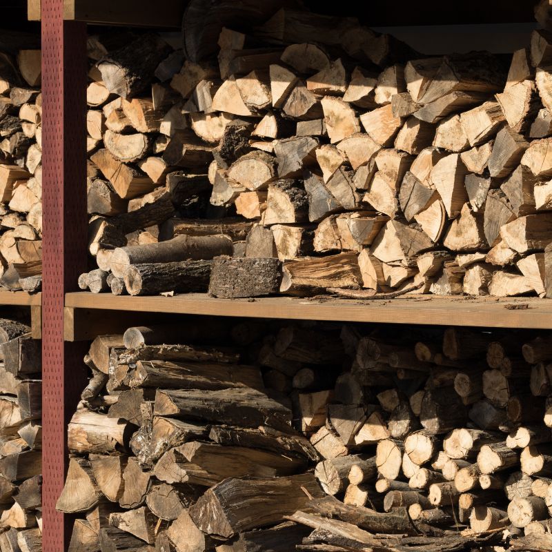 a big storage shed filled with cut pieces of wood that's seasoning